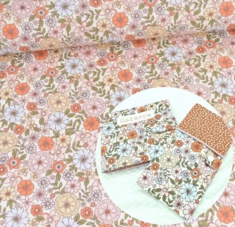 Tissu à motifs floraux aux teintes douces de rose, orange et vert.